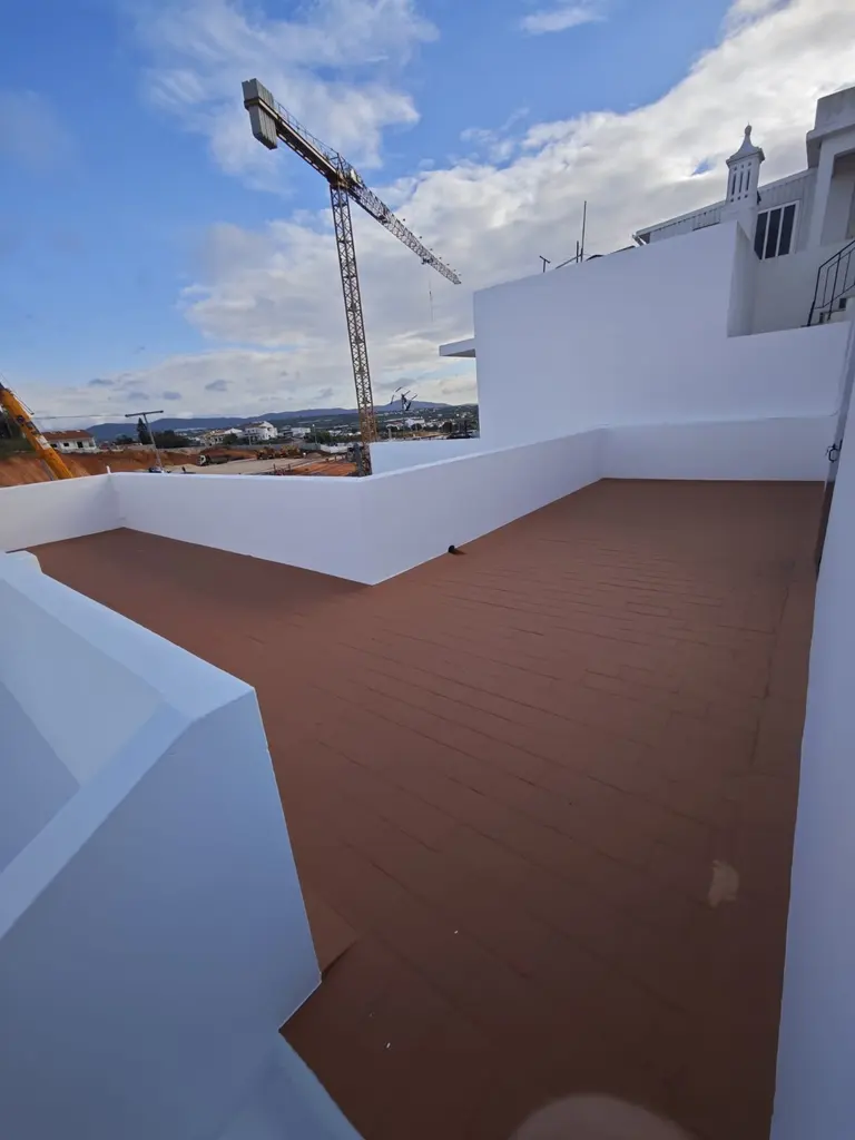 Terraço com pavimento renovado e paredes brancas.